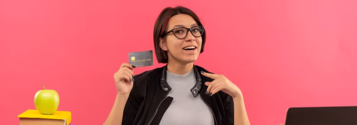 Estudiante revisando una tarjeta de crédito mientras organiza el pago de sus estudios en el exterior
