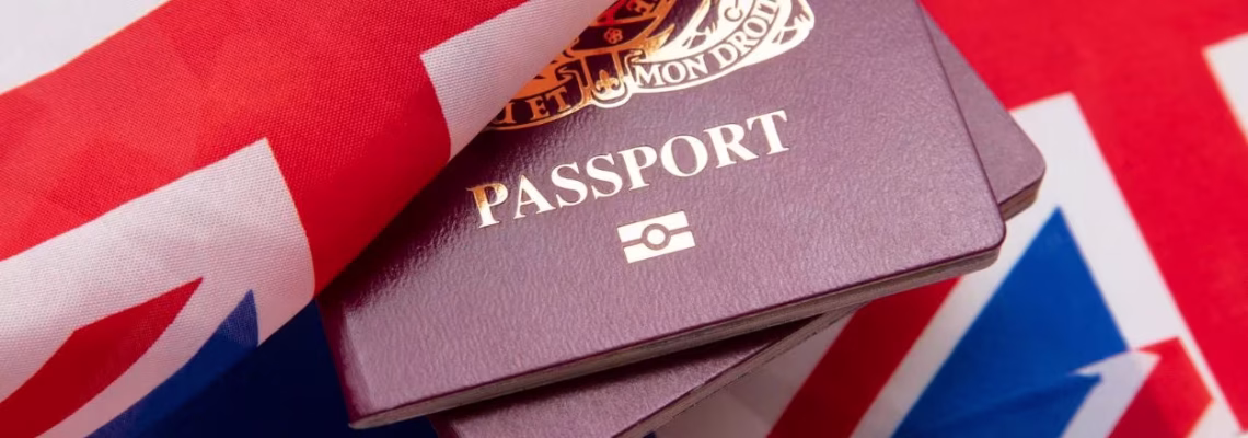 Documento de viaje junto a la bandera de Gran Bretaña para revisar quiénes necesitan visa para entrar a Inglaterra.